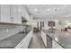 Kitchen with white cabinets, gray backsplash, stainless steel appliances, and granite countertops at 11903 Alessandro Ln, Venice, FL 34293