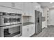 Close up of a stainless steel oven and fridge in a modern kitchen with bright white cabinetry at 11903 Alessandro Ln, Venice, FL 34293