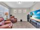 Living room featuring a large television, wood floors, and comfortable leather seating at 11903 Alessandro Ln, Venice, FL 34293