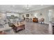 Open-concept living room featuring wood floors, neutral paint, and views to the kitchen and dining room at 11903 Alessandro Ln, Venice, FL 34293