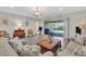 Living room with wood flooring, a sliding glass door to the patio, and neutral-toned furniture at 11903 Alessandro Ln, Venice, FL 34293