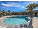 Large community pool with beach entry, palm tree island, and plenty of lounge chairs at 11903 Alessandro Ln, Venice, FL 34293