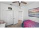 Bright bedroom featuring a ceiling fan, closet, and colorful beach-themed artwork above the bed at 11915 Tempest Harbor Loop, Venice, FL 34292