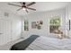 Bedroom with a ceiling fan and views of the surrounding landscaping through multiple windows at 11915 Tempest Harbor Loop, Venice, FL 34292