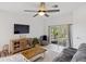 Comfortable living room featuring a ceiling fan and sliding glass doors to a screened patio at 11915 Tempest Harbor Loop, Venice, FL 34292