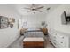 Bright main bedroom boasts a ceiling fan, board and batten accent wall, and ample natural light at 11915 Tempest Harbor Loop, Venice, FL 34292