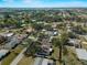 Expansive aerial view showcases the property's location within a community surrounded by mature trees and residential streets at 1212 Mango Ave, Venice, FL 34285