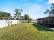 Spacious backyard with lush green grass and a white vinyl privacy fence at 1212 Mango Ave, Venice, FL 34285