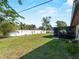 Large backyard featuring green grass and mature trees; a screened patio is visible at 1212 Mango Ave, Venice, FL 34285