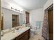 Bright bathroom with decorative framed mirror and patterned shower curtain in tiled standing shower at 1212 Mango Ave, Venice, FL 34285