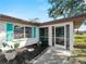 Inviting screened entryway featuring bright shutters, landscaped planting bed and a welcoming entrance at 1212 Mango Ave, Venice, FL 34285