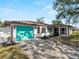 Charming home with a blue garage door, screened porch, and well-maintained landscaping, offering curb appeal at 1212 Mango Ave, Venice, FL 34285