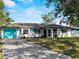 Charming single-story home featuring a bright turquoise garage door, complemented by lush landscaping and a spacious driveway at 1212 Mango Ave, Venice, FL 34285