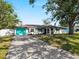 Inviting single-story home featuring a bright blue garage door and a spacious driveway at 1212 Mango Ave, Venice, FL 34285