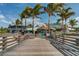 Exterior view of Sharky's entrance from the pier, showcasing the boardwalk and palm trees at 1212 Mango Ave, Venice, FL 34285