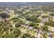 Aerial view showing the home's location within a lush, wooded neighborhood with tree coverage at 1232 Marilyn Ln, North Port, FL 34286