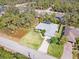 Aerial view of a home with lush green lawn and tropical landscaping, showcasing a desirable location at 1232 Marilyn Ln, North Port, FL 34286