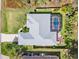 Aerial view of a home featuring a screened-in pool and well-maintained landscaping with firepit at 1232 Marilyn Ln, North Port, FL 34286