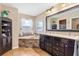 Bathroom boasting a soaking tub with stone accents, dark wood cabinets, and a granite countertop at 1232 Marilyn Ln, North Port, FL 34286