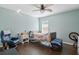 Cozy bedroom with hardwood floors, chair and side table; complete with ceiling fan and natural lighting at 1232 Marilyn Ln, North Port, FL 34286