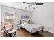 Bedroom with a ceiling fan, wood floors, chair, and window letting in natural light at 1232 Marilyn Ln, North Port, FL 34286