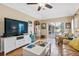 Cozy living room features a ceiling fan, tile flooring, and sliding glass doors leading to the outdoor patio at 1232 Marilyn Ln, North Port, FL 34286