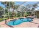 View of backyard pool and enclosure with lush landscape at 1232 Marilyn Ln, North Port, FL 34286