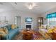 Living room with teal sofas, yellow chairs, and fireplace at 12385 Prudential Ave, Port Charlotte, FL 33981