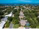 Breathtaking aerial view of a home, nestled in a lush, green neighborhood with a screened pool and waterfront access at 128 Sea Anchor Dr, Osprey, FL 34229