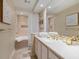 Bright bathroom featuring a soaking tub, white tile, and a vanity with gold fixtures at 128 Sea Anchor Dr, Osprey, FL 34229