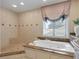 Bathroom featuring soaking tub, walk-in shower and large window at 128 Sea Anchor Dr, Osprey, FL 34229