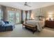 Cozy bedroom with large bed, French doors to the backyard, and neutral decor at 128 Sea Anchor Dr, Osprey, FL 34229