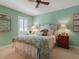 Comfortable bedroom with a queen-size bed, ceiling fan, and window with plantation shutters at 128 Sea Anchor Dr, Osprey, FL 34229