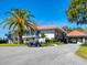 Exterior shot of the clubhouse featuring a blue golf cart and lush landscaping at 128 Sea Anchor Dr, Osprey, FL 34229