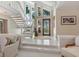 Elegant foyer with staircase, marble floors, and decorative glass front door welcomes you home at 128 Sea Anchor Dr, Osprey, FL 34229