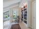 Upstairs hallway featuring a built-in bookcase and a door to an outdoor balcony at 128 Sea Anchor Dr, Osprey, FL 34229