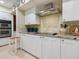 Well-lit kitchen featuring white cabinets, stainless steel appliances, and complementary stone countertops and backsplash at 128 Sea Anchor Dr, Osprey, FL 34229