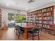 Cozy library with floor-to-ceiling bookshelves, a large table, and a balcony overlooking trees at 128 Sea Anchor Dr, Osprey, FL 34229