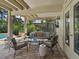 Covered patio with plenty of seating for a relaxing view of the outdoor landscape and adjacent screened-in pool area at 128 Sea Anchor Dr, Osprey, FL 34229