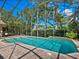 Screened-in pool area with a brick patio and lush tropical landscaping at 128 Sea Anchor Dr, Osprey, FL 34229