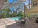 Large screened-in pool area with an outdoor dining set and outdoor seating area at 128 Sea Anchor Dr, Osprey, FL 34229