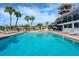 Community pool featuring lounge chairs, tables, and umbrellas, all surrounded by lush tropical landscaping at 128 Sea Anchor Dr, Osprey, FL 34229