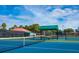 Well-maintained tennis court facility with a covered viewing area and lush landscaping at 128 Sea Anchor Dr, Osprey, FL 34229