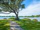 Scenic waterfront park featuring shaded benches and lush green grass with tranquil water views at 128 Sea Anchor Dr, Osprey, FL 34229