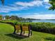 A waterfront view with benches surrounded by lush greenery in a serene outdoor setting at 128 Sea Anchor Dr, Osprey, FL 34229