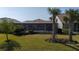 Expansive backyard with lawn and tall palm trees bordering screened in patio at 13194 Borrego St, Venice, FL 34293