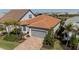 This aerial view displays a home with a tile roof, a gray garage door, and a beautifully manicured lawn at 13194 Borrego St, Venice, FL 34293