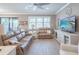 Bright living room with hardwood floors, a ceiling fan, and a view of the screened in patio at 13194 Borrego St, Venice, FL 34293