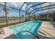 Inviting screened pool area with seating, a gator statue and serene lake view at 13194 Borrego St, Venice, FL 34293