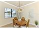 Bright dining room features a wooden table with seating for four and a view to the backyard at 13376 Caravaggio Ct, Venice, FL 34293